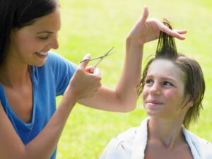 Boy gets his hair cut by woman