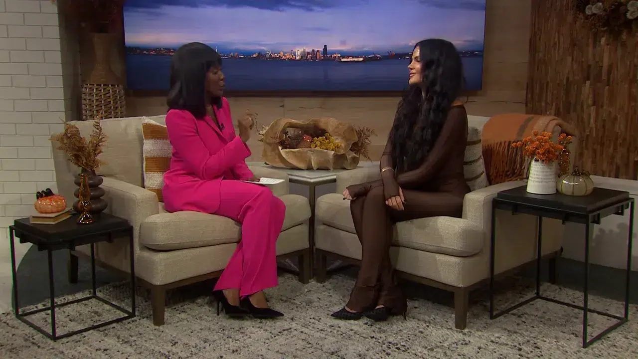 Moderatorin und Gast im Studio bei einem Gespräch über Haartrends 2026, Weitwinkelaufnahme